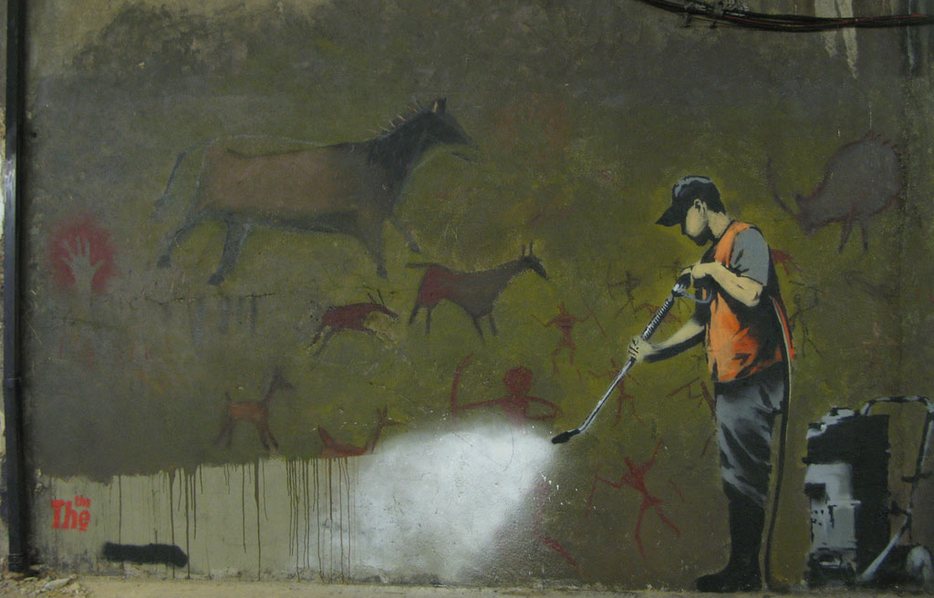 گرافیتی نقاشی انسان‌های غارنشین که توسط انسان مدرن داره پاک می‌شه